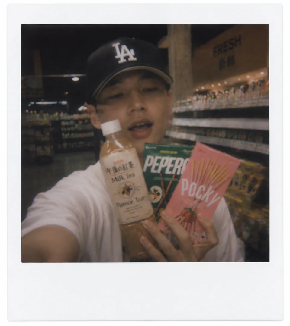 Student holding Asian drinks and snacks in a market